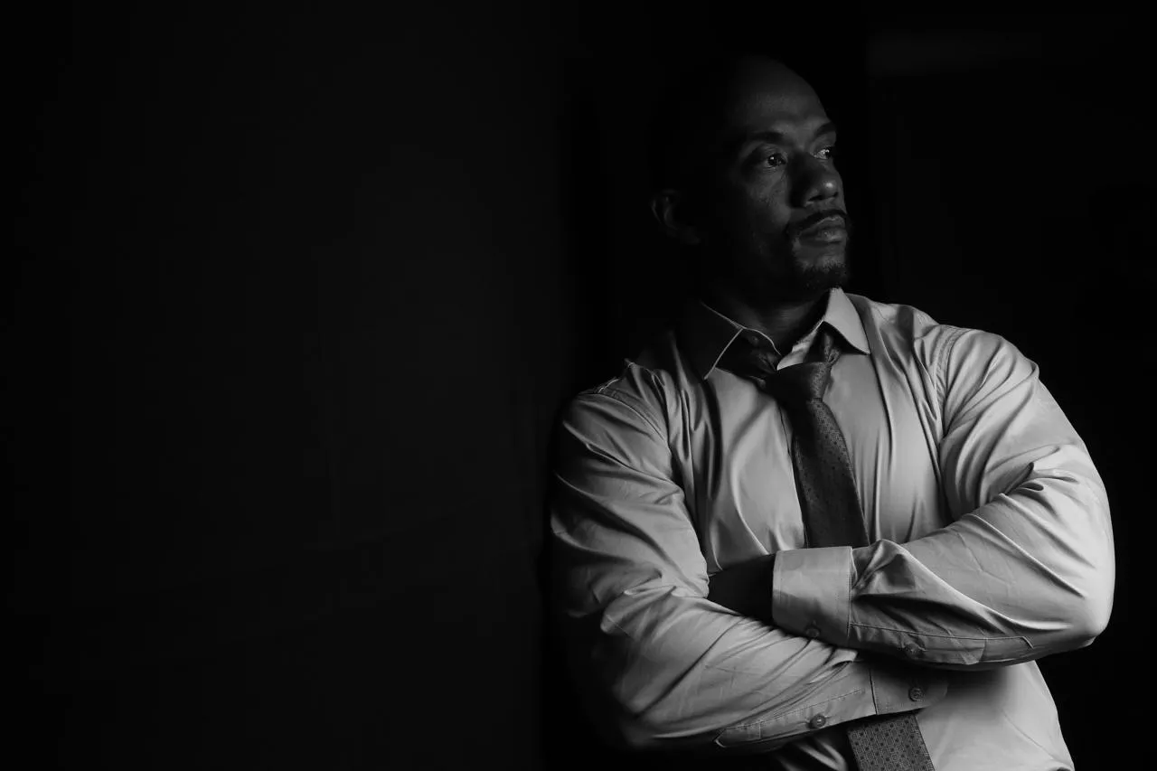 Adriano Rodrigues, retrato em preto e branco, de braços cruzados